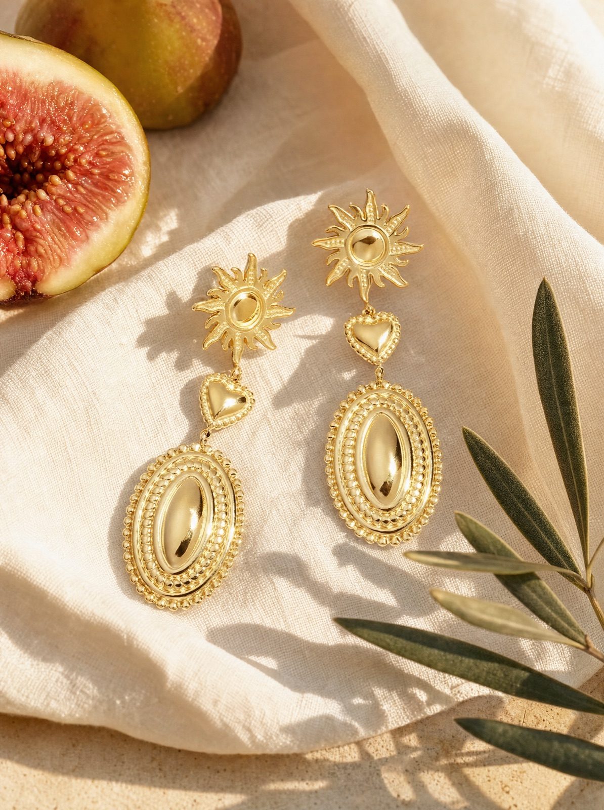 sun and heart drop earrings in gold on cream linen