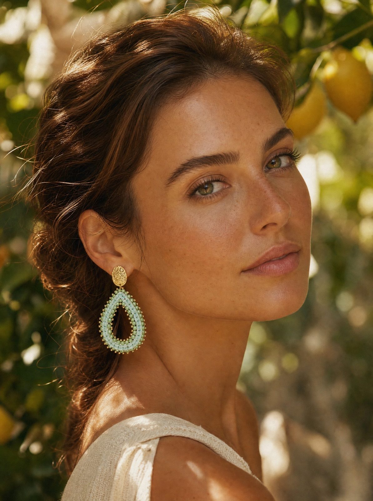 woman wearing the riviera drops in mint green in soft garden light