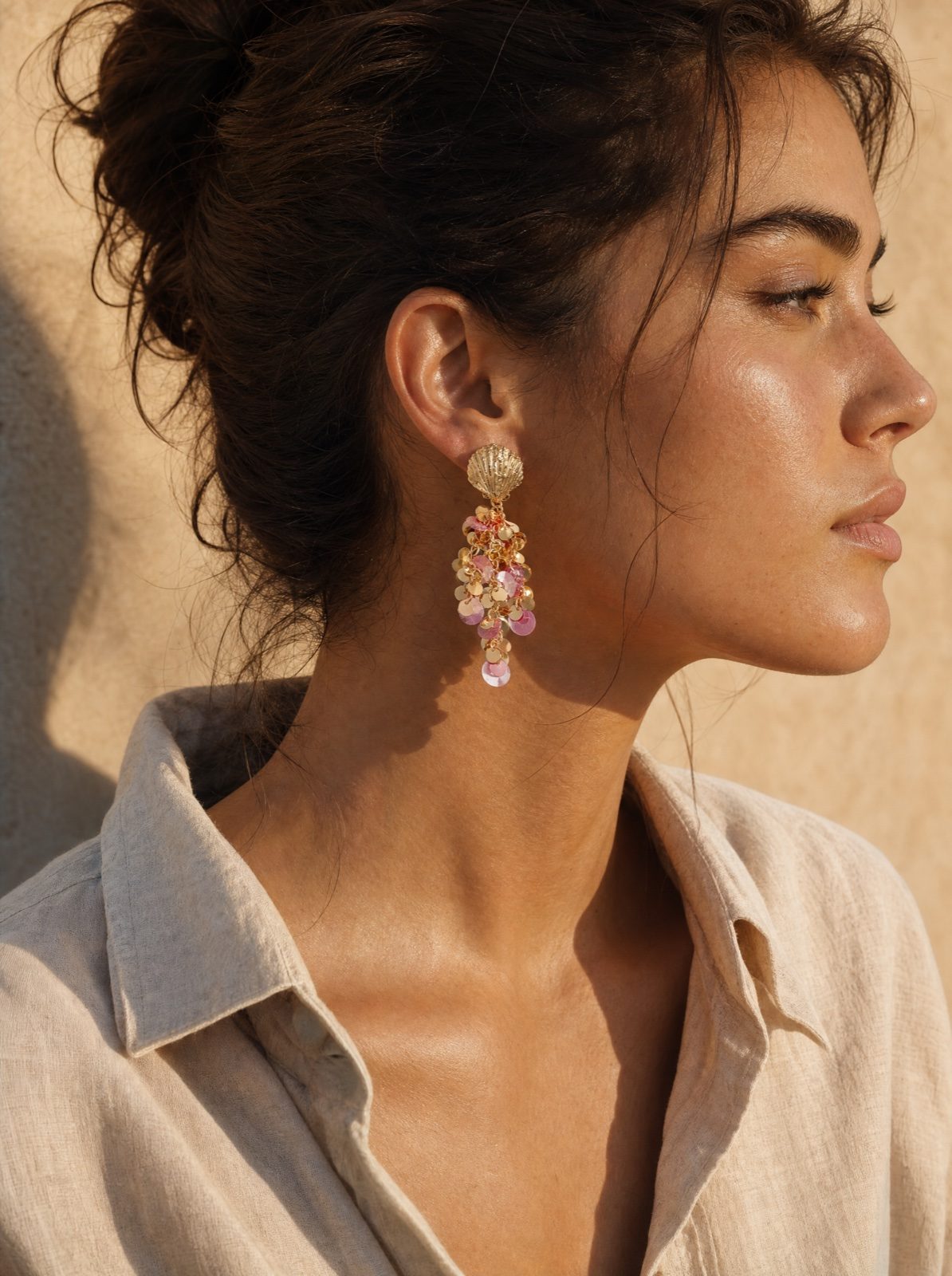 woman wearing the shell earrings with hanging pink sequins, side profile in sun-lit afternoon