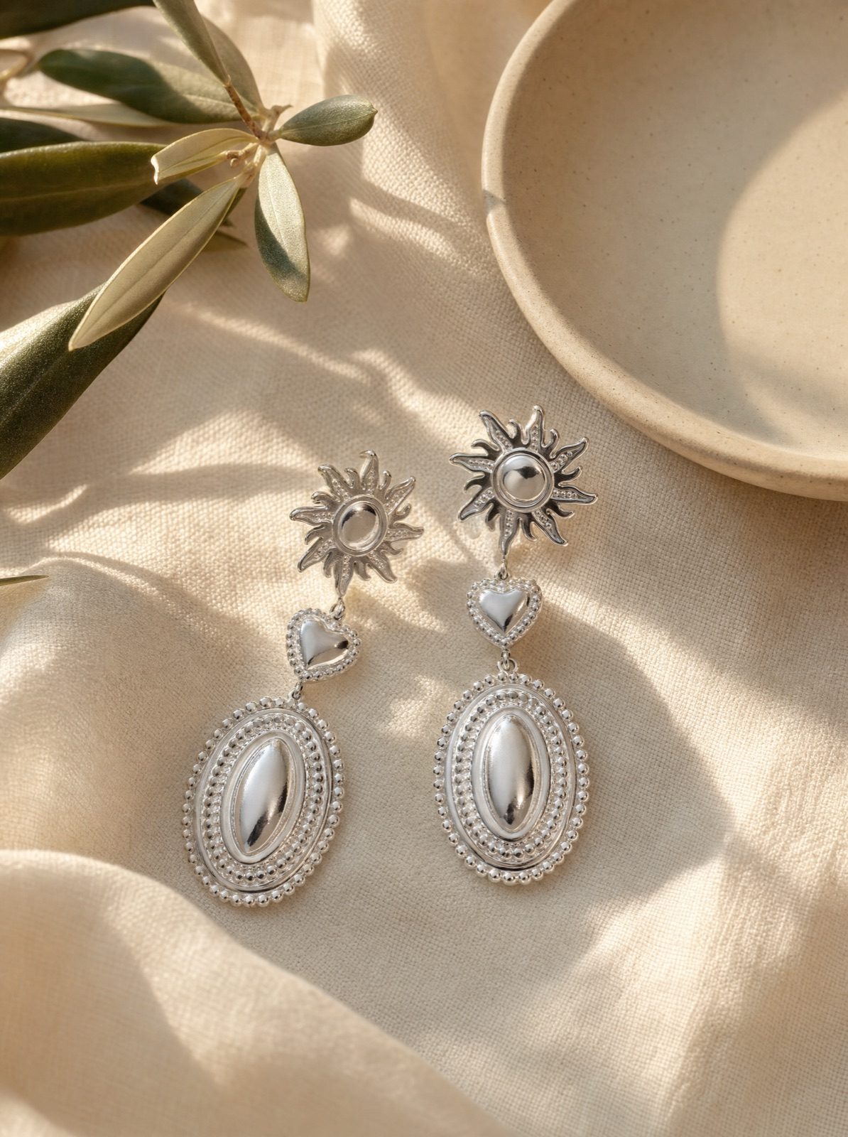 sun and heart drop earrings in silver on cream linen