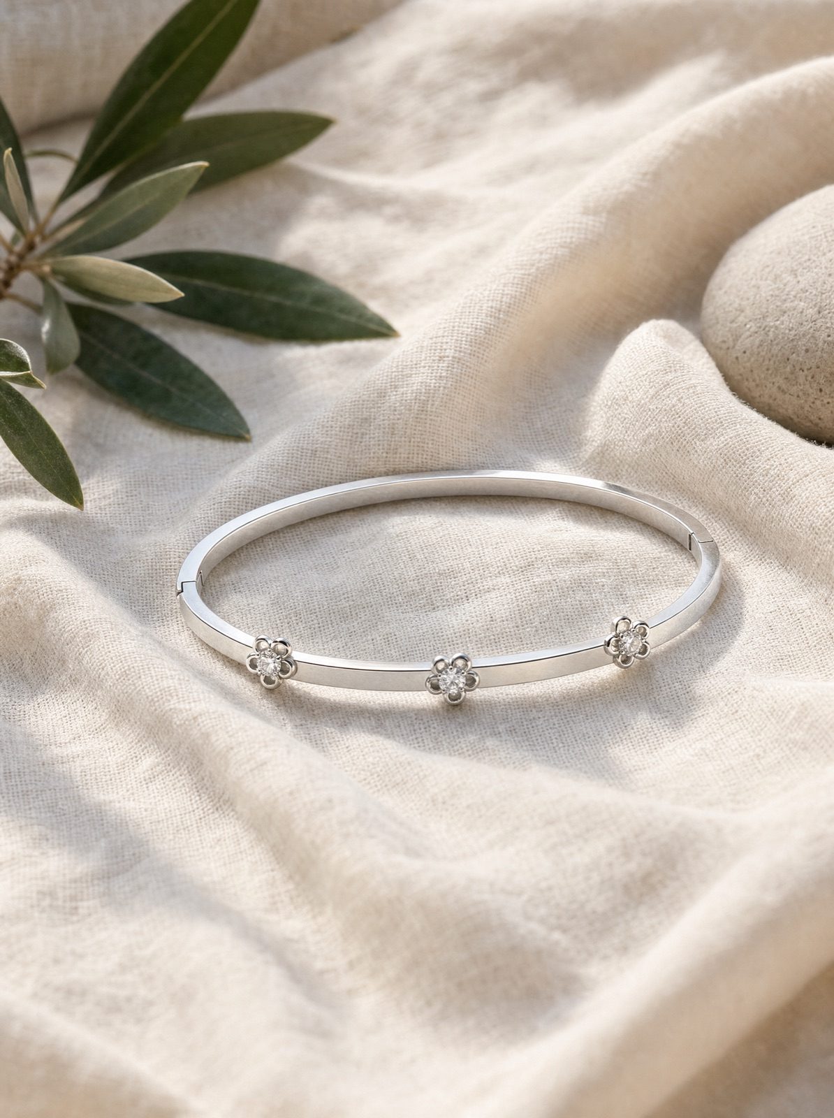 fiore bangle in silver on cream linen with an olive branch